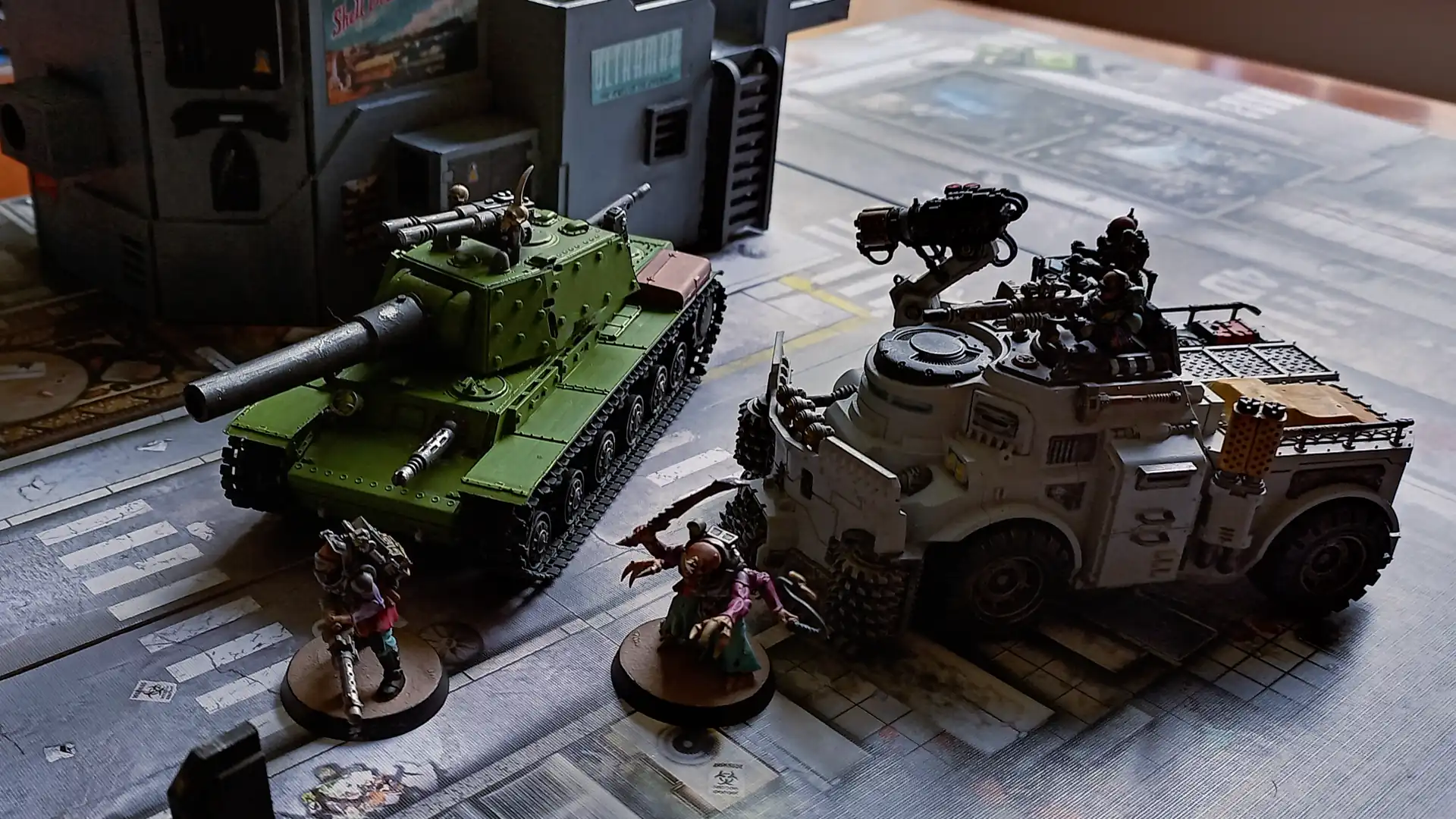 Another angle of a model tank and a model truck. The tank appears slightly smaller than, or at best the same size as, the truck.